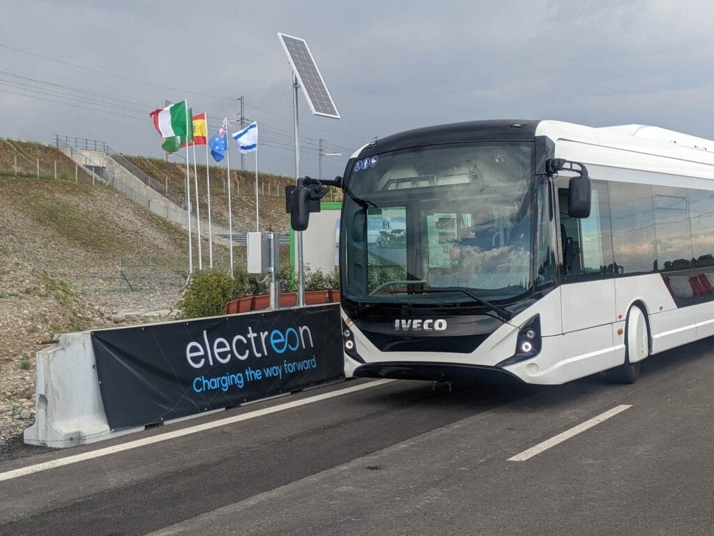 Iveco bus beside Electreon sign