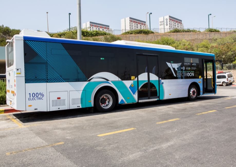 Bus at a wireless ev charging station in a busy neighborhood 