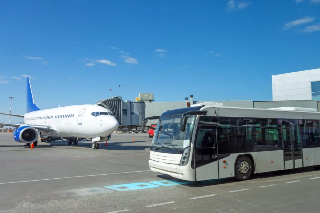 White passenger bus for transporting people from the terminal building to the aircraft ramp during the flight departure procedure